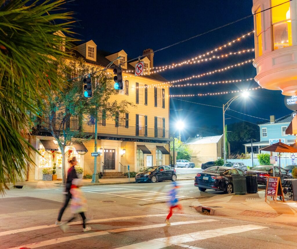Sunlit street in a historic Savannah neighborhood, with elegant townhouses and trees draped in Spanish moss, evoking a sen...