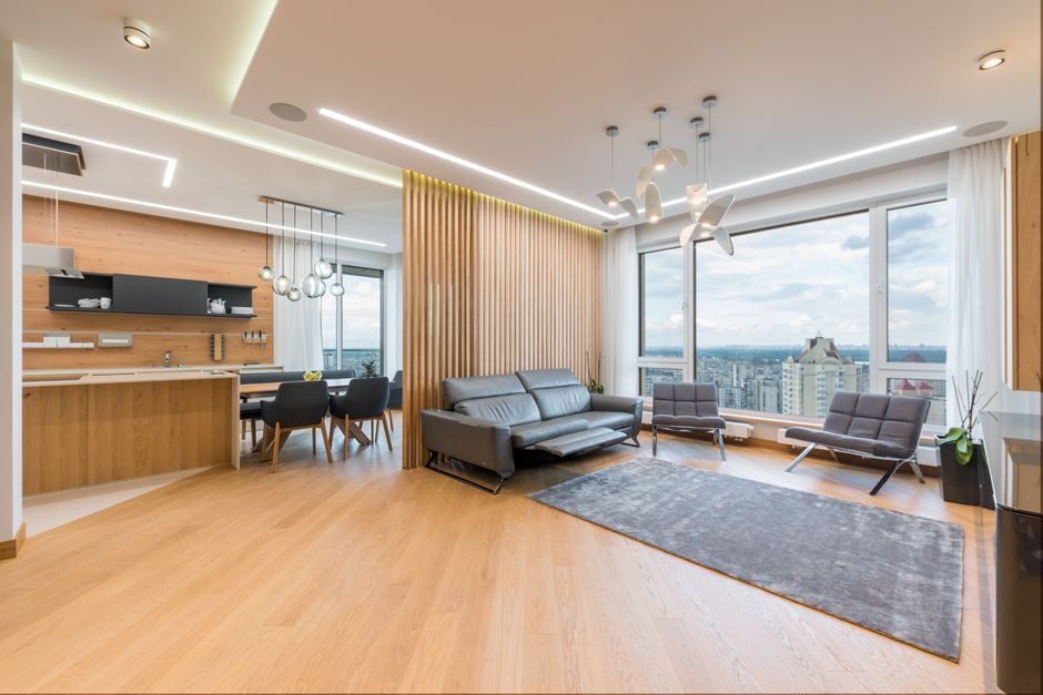 Bright, modern living room with large windows offering a stunning view of the Atlanta city skyline, representing the appea...