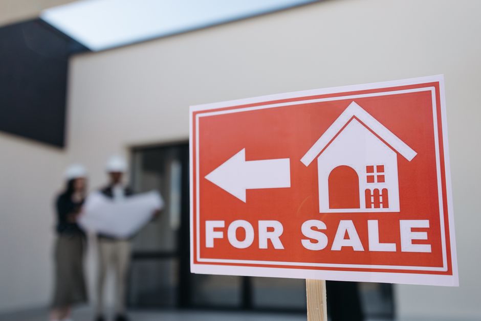 A sleek, modern 'For Sale' sign in front of a beautiful contemporary home, representing a successful and profitable real estate transaction.