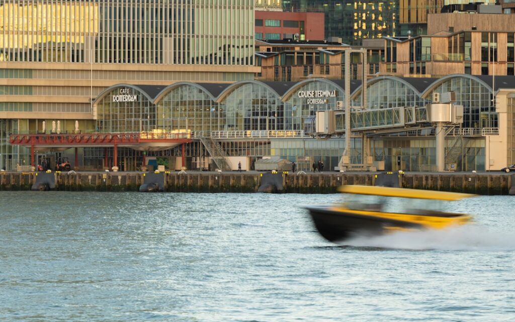 Sleek, modern speedboat creating a wake as it swiftly passes a massive cargo ship, symbolizing agility and speed overcomin...