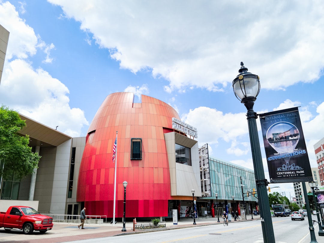 A vibrant, modern street in an upscale Atlanta neighborhood, bustling with people enjoying outdoor cafes and shops, showcasing the premium amenities found near corporate centers.